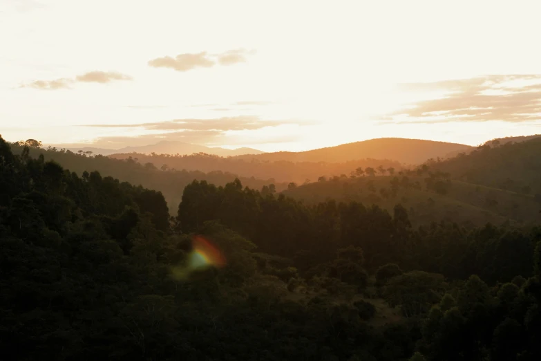 the sun is setting over the mountains in the distance, unsplash contest winner, australian tonalism, lush forest in background, tamborine, golden hour hues, wide wide shot