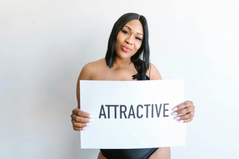 a woman holding a sign that says attractive, plus size, muscular body type, profile image, photoshoot