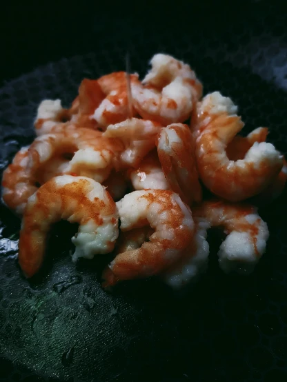 a pile of shrimp sitting on top of a black plate, unsplash, hurufiyya, ☁🌪🌙👩🏾, medium format. soft light, iphone photo, thumbnail