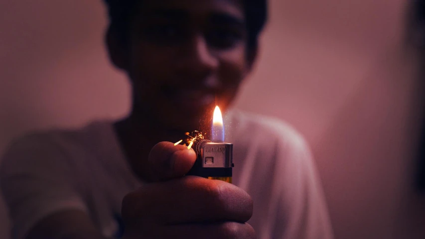 a person holding a lighter in their hand, pexels contest winner, teen boy, mohamed chahin, medium format. soft light, candle