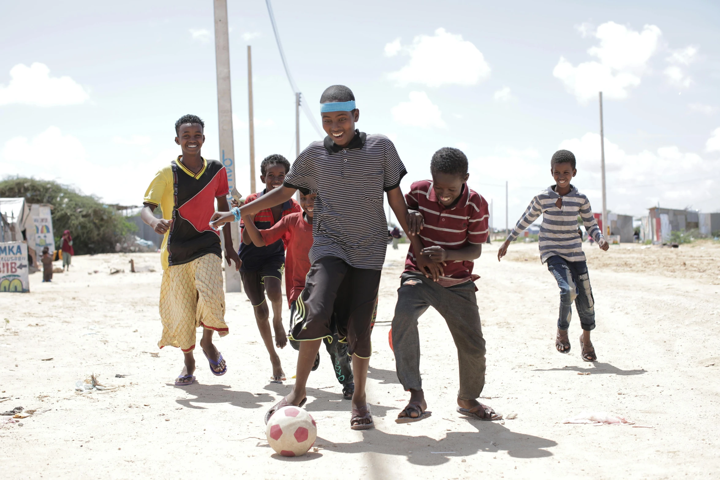 a group of young men playing a game of soccer, happening, somalia, fan favorite, square, medium