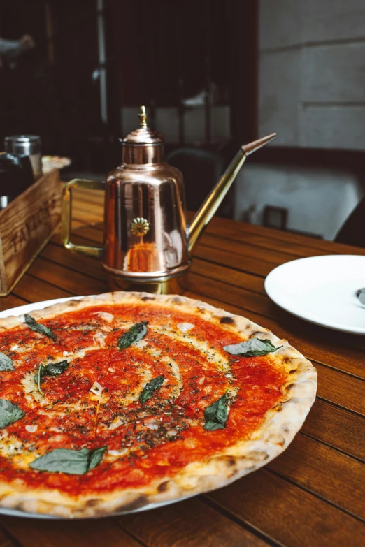 a pizza sitting on top of a wooden table, silver gold red details, ‘luca’, plated arm, cosy