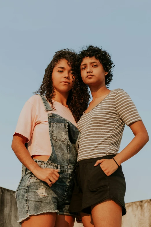 a couple of women standing next to each other, trending on pexels, latino american, young teen, promotional image, curls