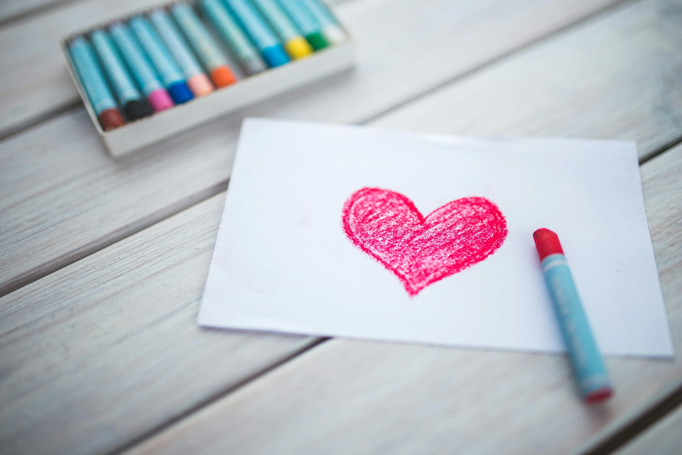 a piece of paper with a heart drawn on it, a child's drawing, pexels contest winner, crayon art, colouring pages, beauty shot, over the shoulder, a wooden