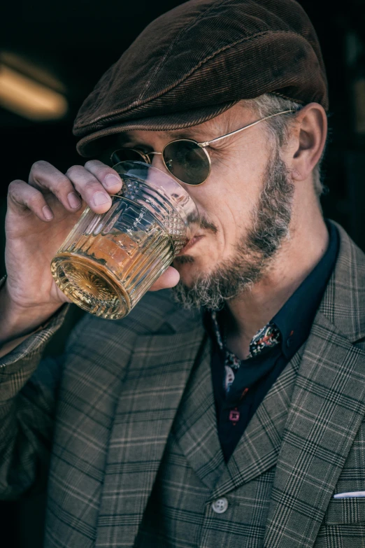 a man in a suit drinking from a glass, a portrait, inspired by Harry Haenigsen, pexels, tweed colour scheme, hipster dad, dressed in a worn, festivals