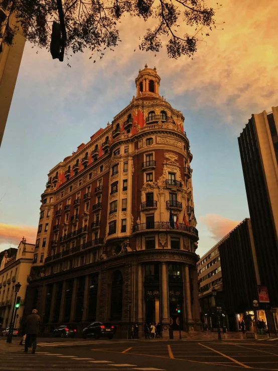 a tall building sitting on the side of a street, by Hirosada II, pexels contest winner, art nouveau, golden hour hues, spanish, iphone photo, high - angle view