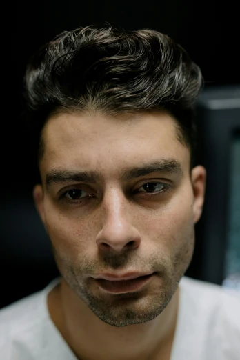 a man standing in front of a computer monitor, a character portrait, by Adam Dario Keel, reddit, chiseled jawline, joseph moncada, headshot photograph, high angle closeup portrait