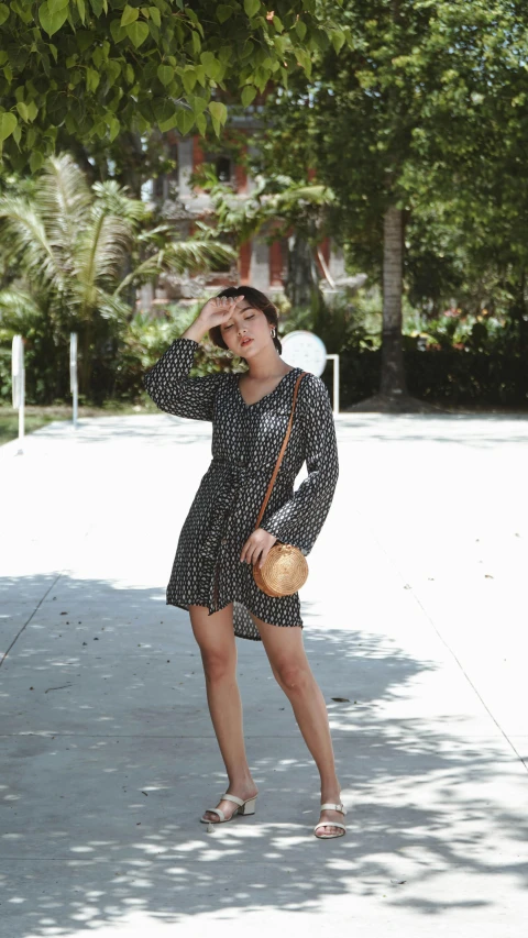 a woman standing on a sidewalk talking on a cell phone, inspired by Max Buri, unsplash, hurufiyya, short dress, patterned, low quality photo, thumbnail