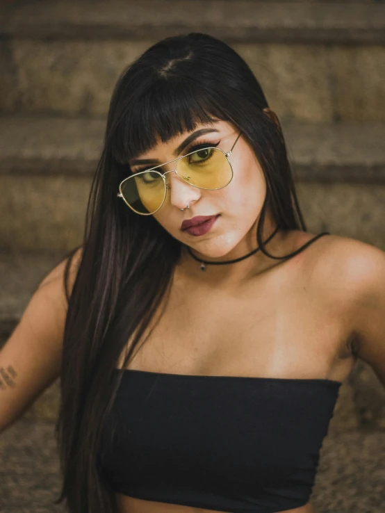 a woman in a black bikini top and yellow sunglasses, inspired by Elsa Bleda, trending on pexels, renaissance, young middle eastern woman, frontal picture, high lights, cynthwave