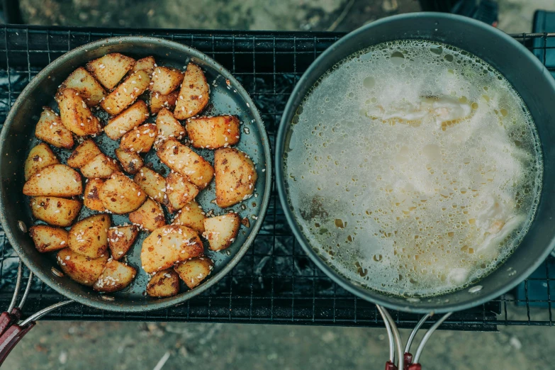 two pans filled with food sitting on top of a grill, a photo, unsplash, potatoes, square, nuttavut baiphowongse, honey