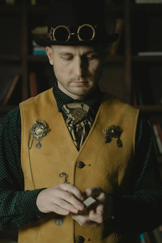 a man standing in front of a bookshelf holding a cell phone, inspired by Augustus Vincent Tack, trending on unsplash, renaissance, in detailed steampunk dress, wearing waistcoat, close-up portrait film still, cowboy portrait