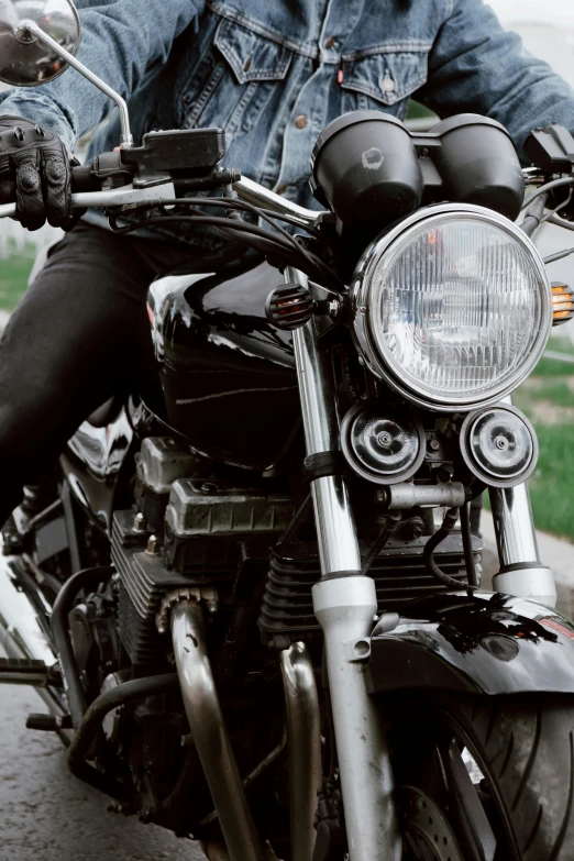 a man riding on the back of a motorcycle down a street, unsplash, photorealism, with cool headlights, front closeup, a pair of ribbed, shiny silver