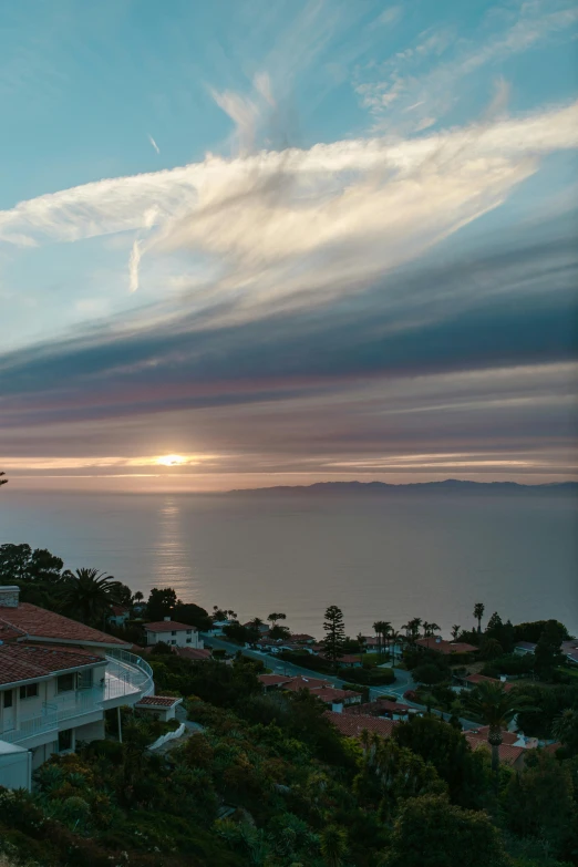 a house sitting on top of a hill next to the ocean, cloudy sunset, slide show, los angeles ca, view from above