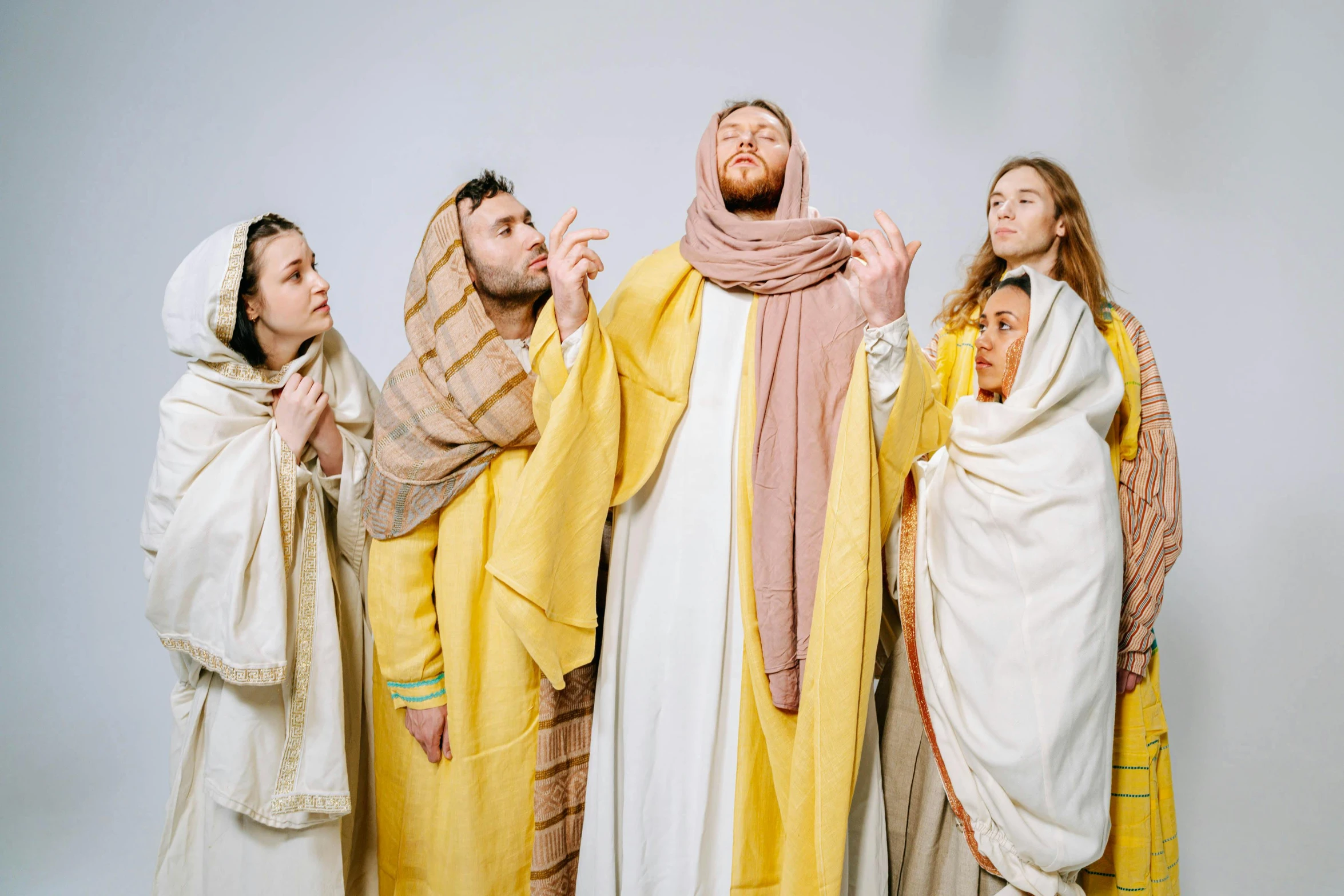 a group of people dressed in biblical clothing, an album cover, inspired by Moses van Uyttenbroeck, pexels, yellow clothes, 256435456k film, dressed in a robe, religious