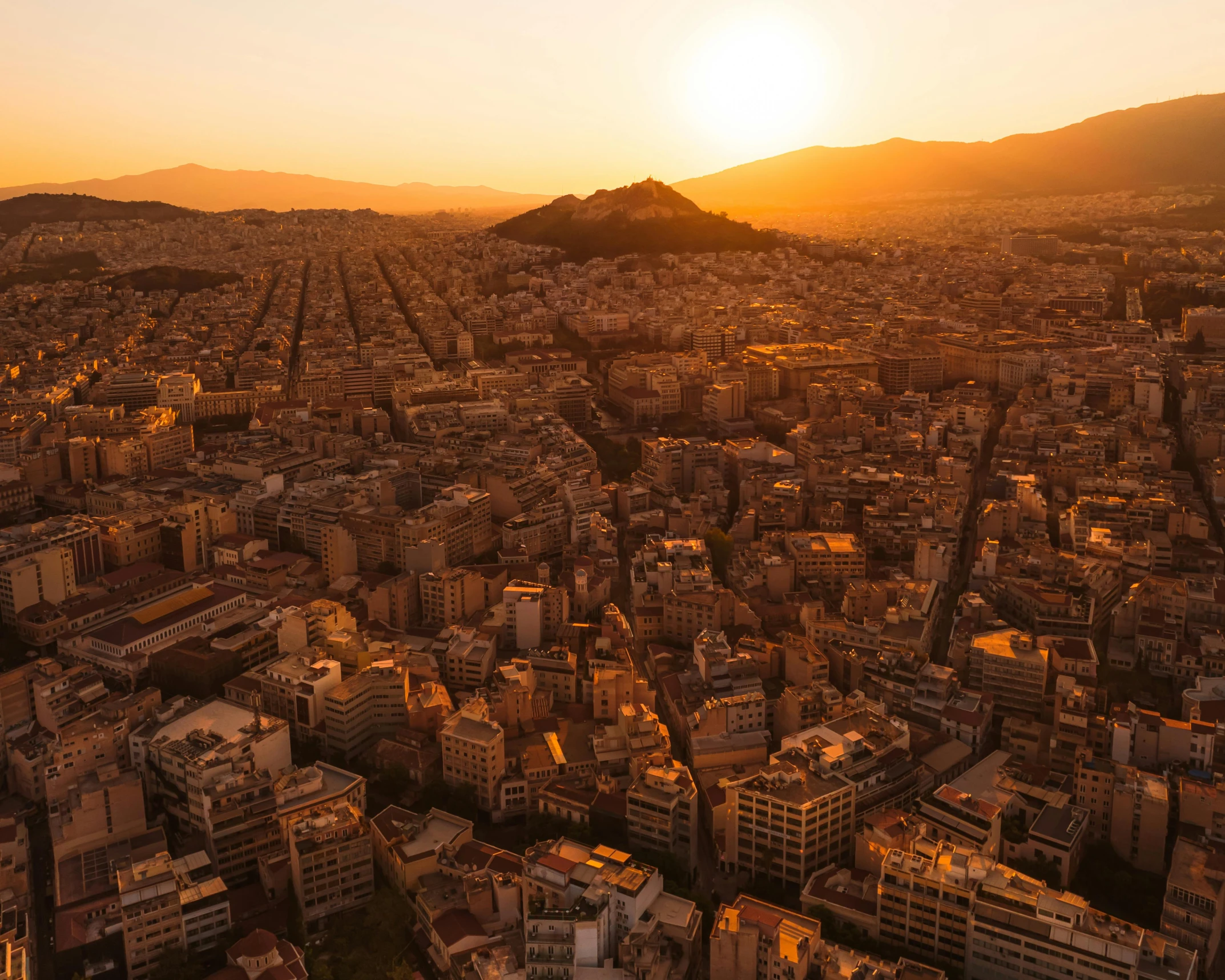 an aerial view of a city at sunset, by Alexis Grimou, pexels contest winner, neoclassicism, square, greek, sparkling in the sunlight, brown