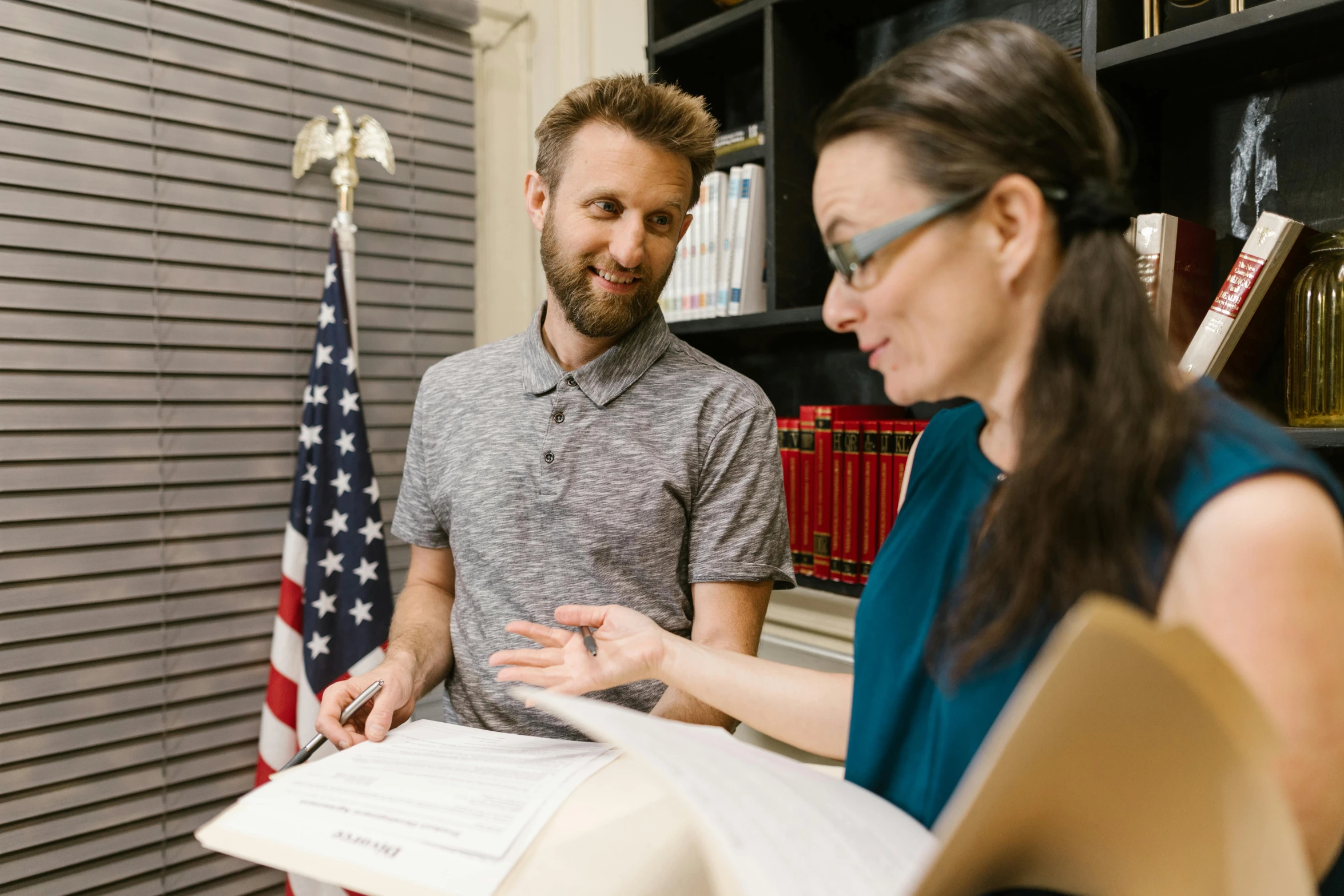 a man and a woman looking at a book, official documentation, zach hill, in the office, profile image