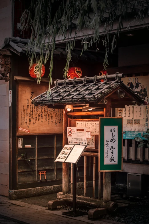 a small building with a sign in front of it, inspired by Watanabe Shōtei, trending on unsplash, ukiyo-e, evening lanterns, tavern, high-quality photo, archways made of lush greenery