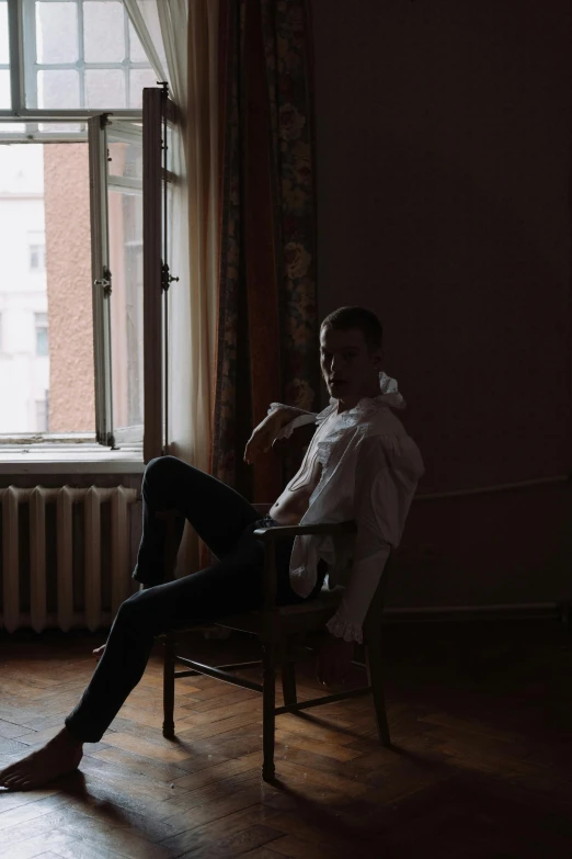 a man sitting in a chair in front of a window, an album cover, inspired by Elsa Bleda, pexels contest winner, renaissance, young handsome pale roma, daniil kudriavtsev, morning coffee, elegant pose