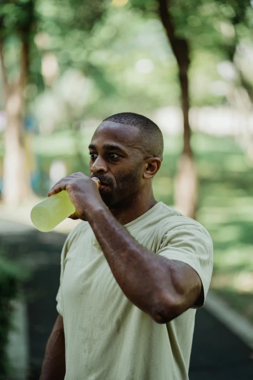 a man holding a frisbee in his right hand, pexels contest winner, drinking tea, wearing a muscle tee shirt, slight yellow hue, african american