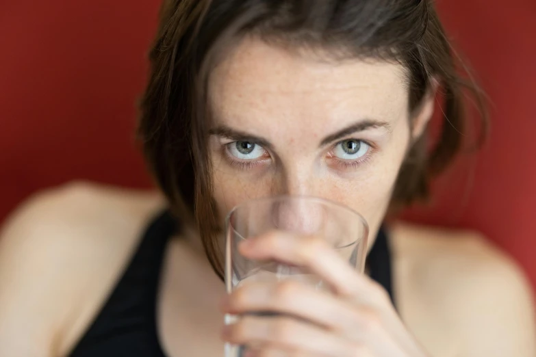 a woman drinking a glass of water, a portrait, by Jan Rustem, pexels, close up at face, mid 2 0's female, stoya, downward gaze