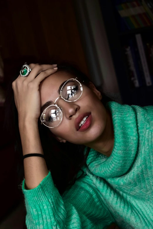a woman wearing glasses and a green sweater, inspired by Anita Malfatti, trending on pexels, rings, ashteroth, silver silver glasses, oona chaplin
