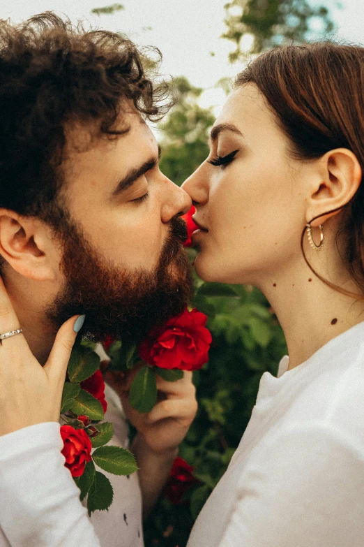 a man giving a woman a kiss on the cheek, a photo, by Julia Pishtar, romanticism, small red roses, thick beard, promo image, vine