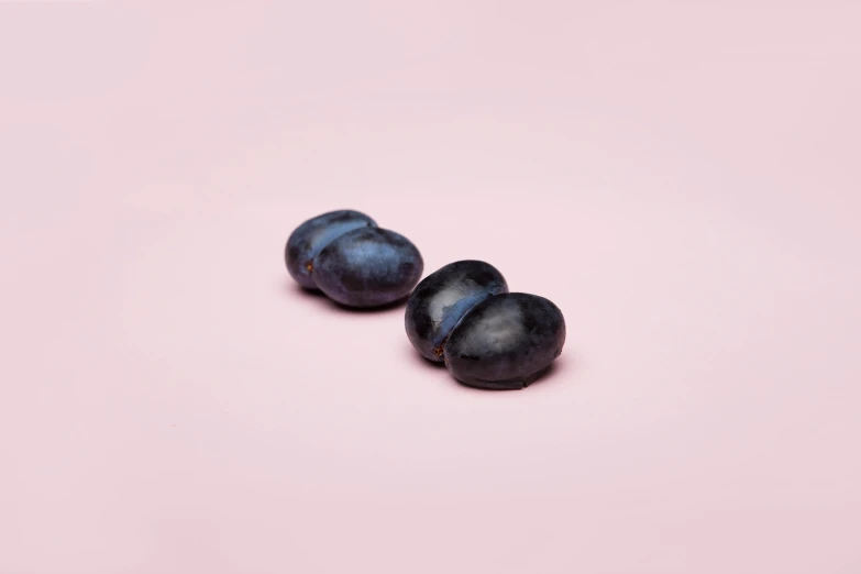 two plums on a pink background, unsplash, photorealism, made of smooth black goo, beans, dark blue skin, 3/4 front view