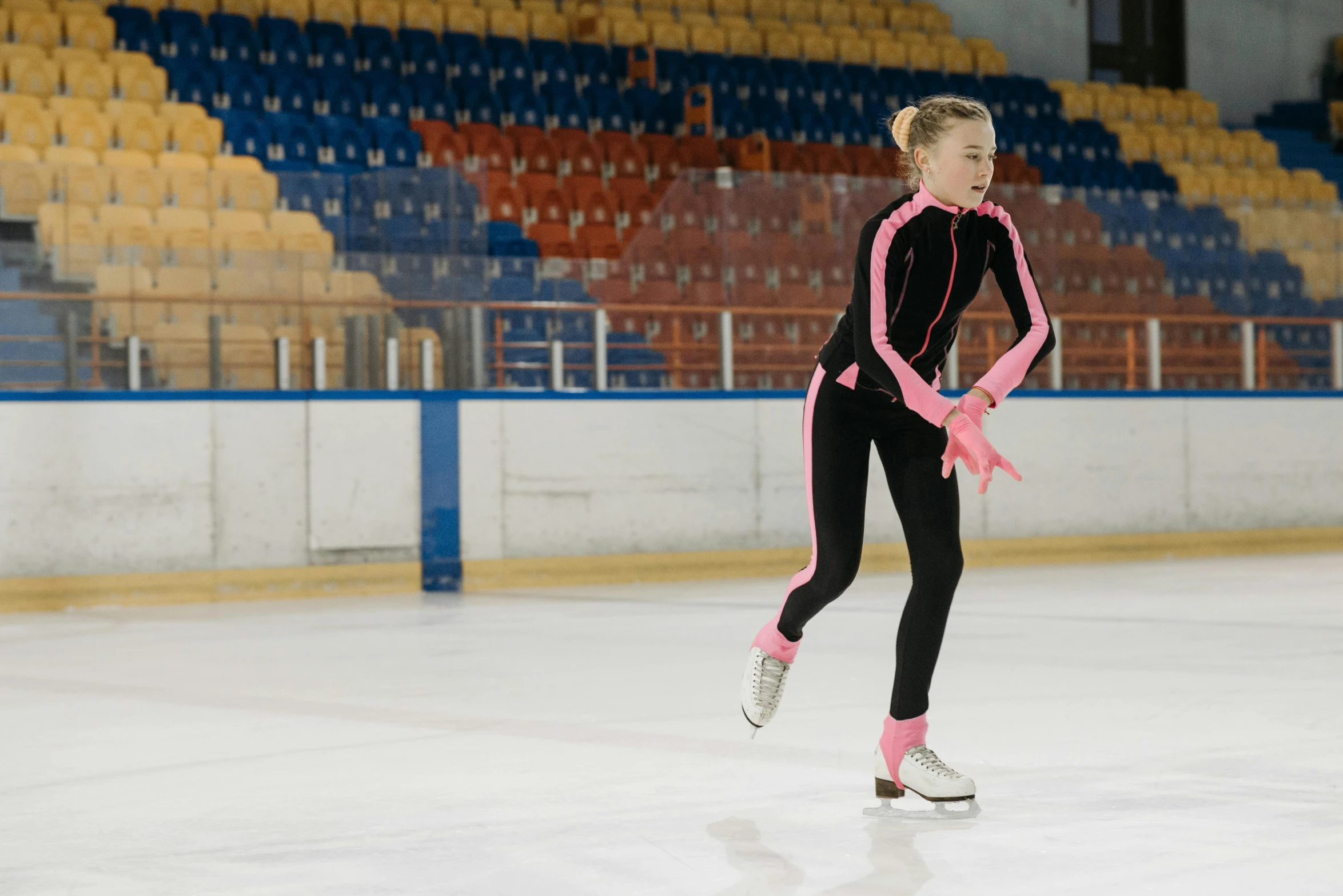 a female figure skating on an ice rink, a portrait, by Tom Bonson, shutterstock, wearing a tracksuit, pink, blonde, indoor picture