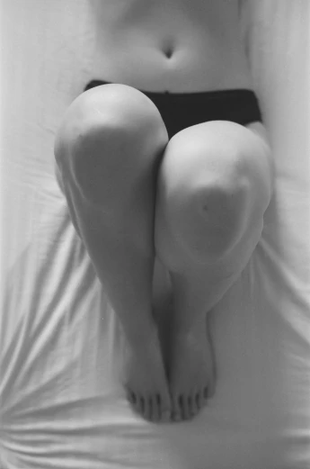 a black and white photo of a woman laying on a bed, inspired by Hans Bellmer, tumblr, thighs thighs thighs thighs, legs taking your pov, identical picture, thicc