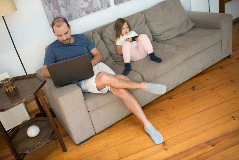 a man and a little girl sitting on a couch, pexels, working, leg and hip shot, caucasian, sweat and labour