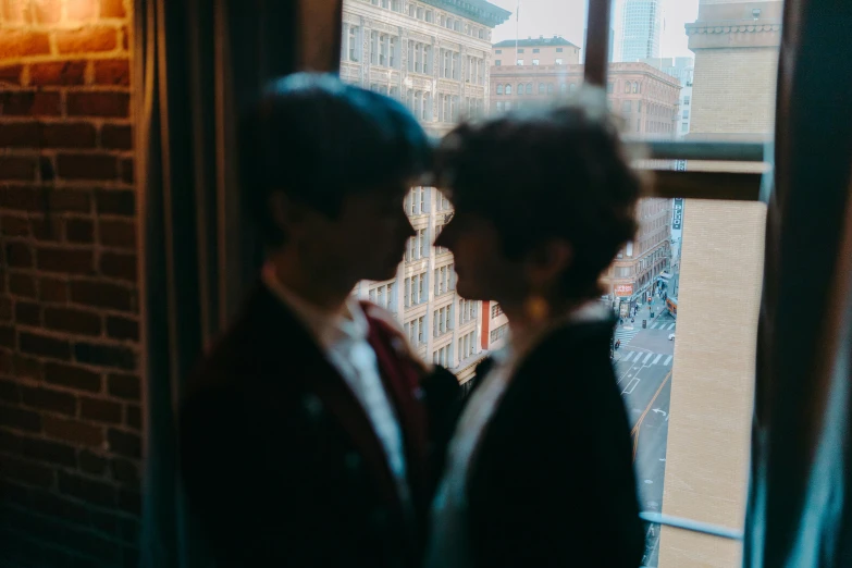 a couple of people standing in front of a window, by Nina Hamnett, pexels contest winner, declan mckenna, facing each other, close up shot from the top, lgbtq