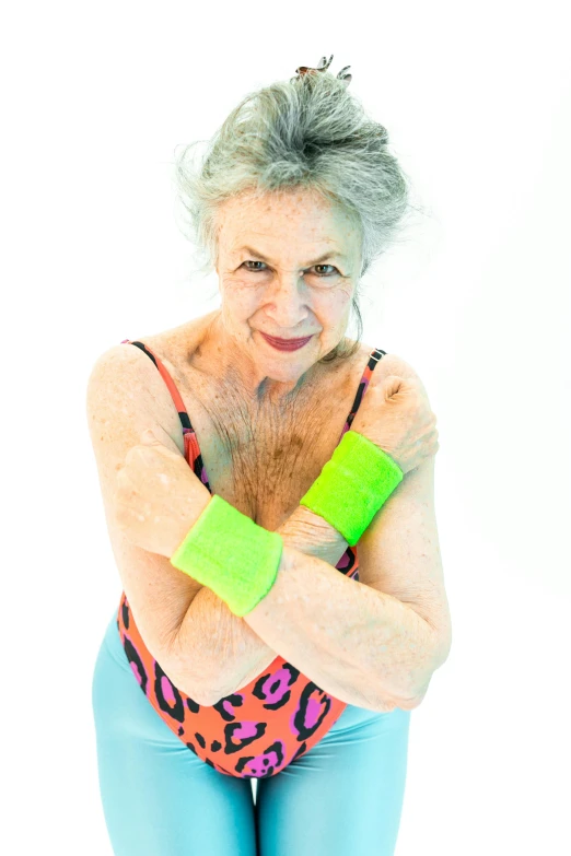 an older woman posing for a picture in a leoper leoper leoper leoper leoper leoper leoper leoper leoper leo, an album cover, inspired by Bert Stern, chartreuse and orange and cyan, bandage on arms, wearing fitness gear, press shot