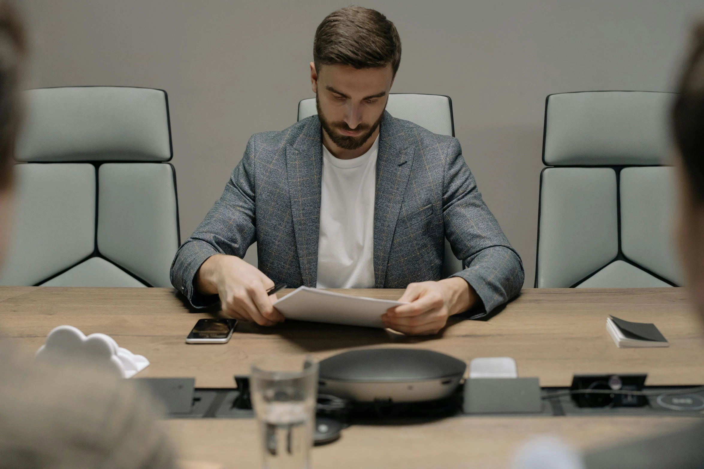 a man sitting at a table with a tablet in front of him, by Adam Marczyński, pexels contest winner, hyperrealism, in a meeting room, avatar image, bang olufsen, elegantly dressed