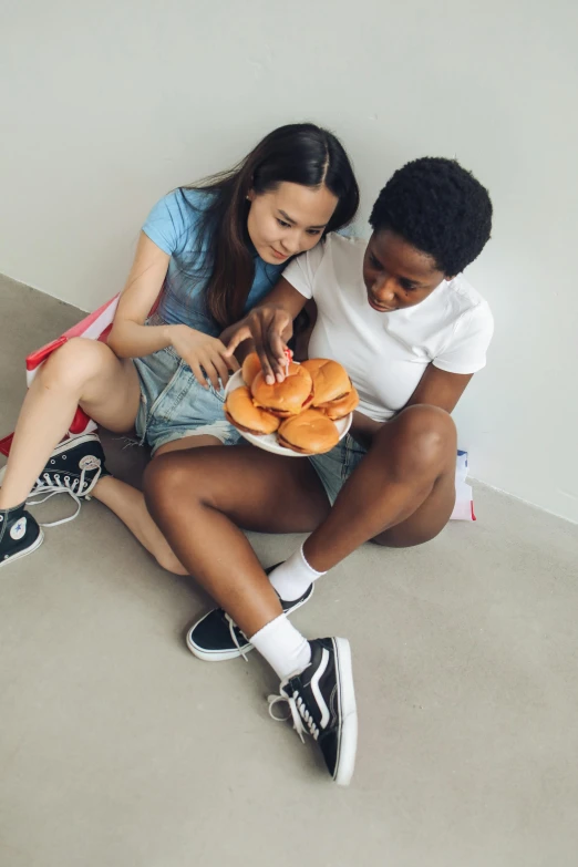 a man and a woman sitting on the floor eating donuts, inspired by Sarah Lucas, trending on unsplash, hyperrealism, black teenage girl, bra and shorts streetwear, lesbian embrace, holding toasted brioche bun