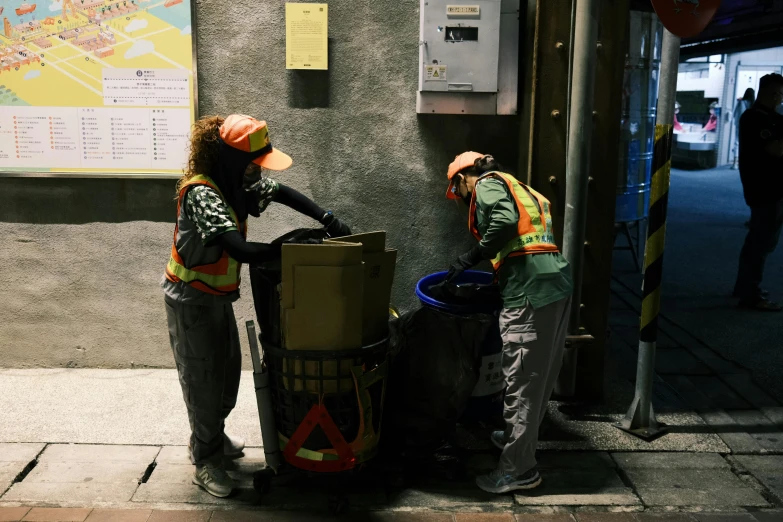 a couple of people standing next to a trash can, unsplash, process art, under repairs, avatar image, working clothes, during the night