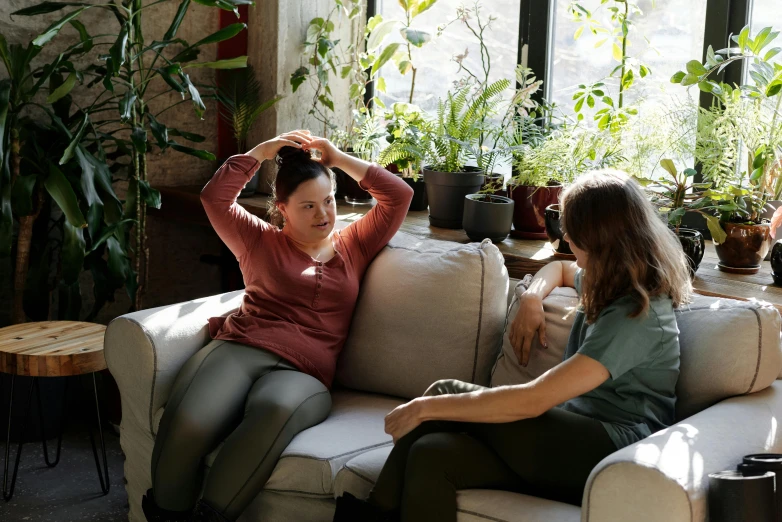 a couple of women sitting on top of a couch, by Alice Mason, pexels contest winner, hurufiyya, touching heads, recovering from pain, biophilia mood, playing