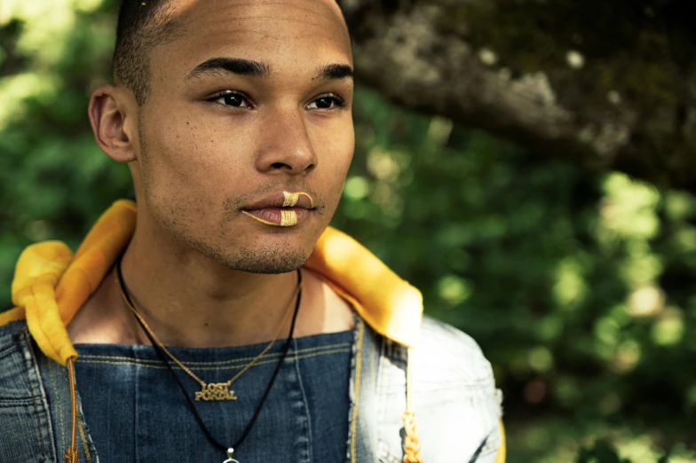 a man with a cigarette in his mouth, an album cover, inspired by Barthélemy Menn, unsplash, rapper jewelry, mixed race, gold choker, grain”