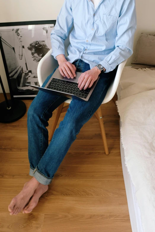 a woman sitting in a chair with a laptop, inspired by Jean Malouel, trending on unsplash, renaissance, jeans pants, wearing a light blue shirt, high angle shot, full - body - front - shot