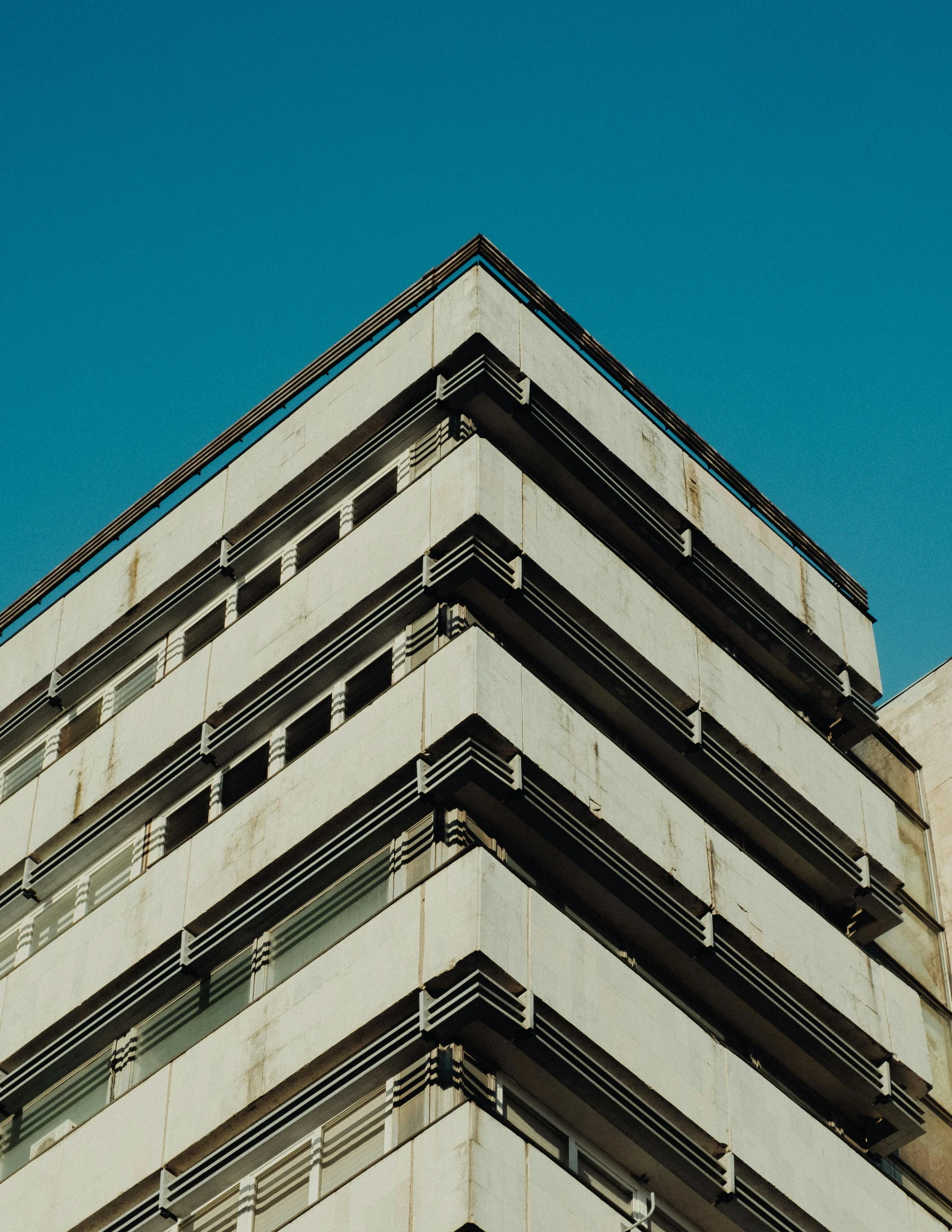 a tall building with a clock on top of it, inspired by Bauhaus, unsplash, brutalism, square lines, low quality photo, “derelict architecture buildings, corners