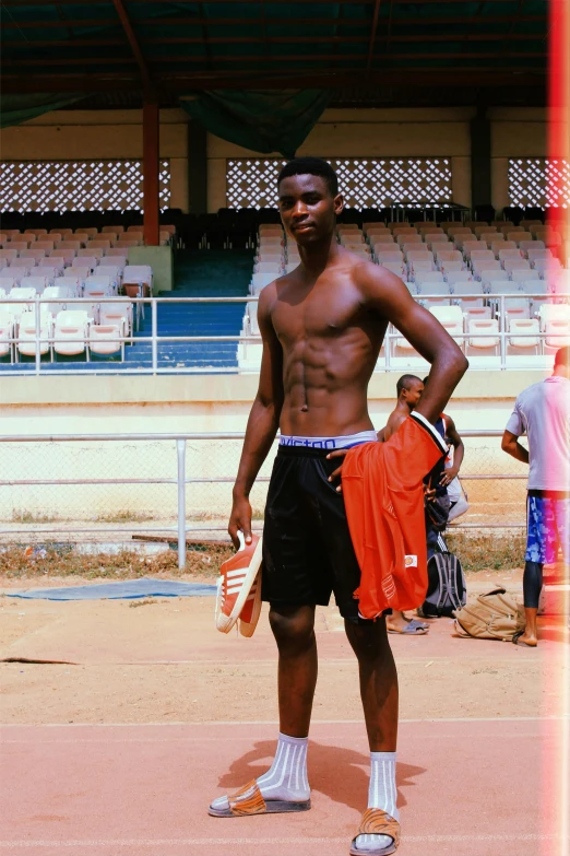 a man standing on top of a tennis court holding a racquet, an album cover, by Chinwe Chukwuogo-Roy, pexels contest winner, happening, athletic body build, he is about 20 years old | short, football, casually dressed