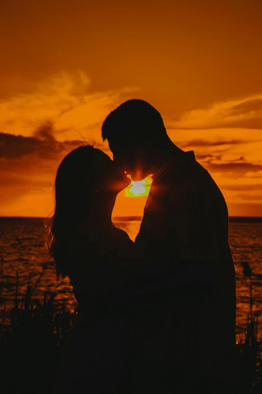 a couple kissing in front of a sunset, on a lake, during a sunset, overlooking the ocean, smoldering