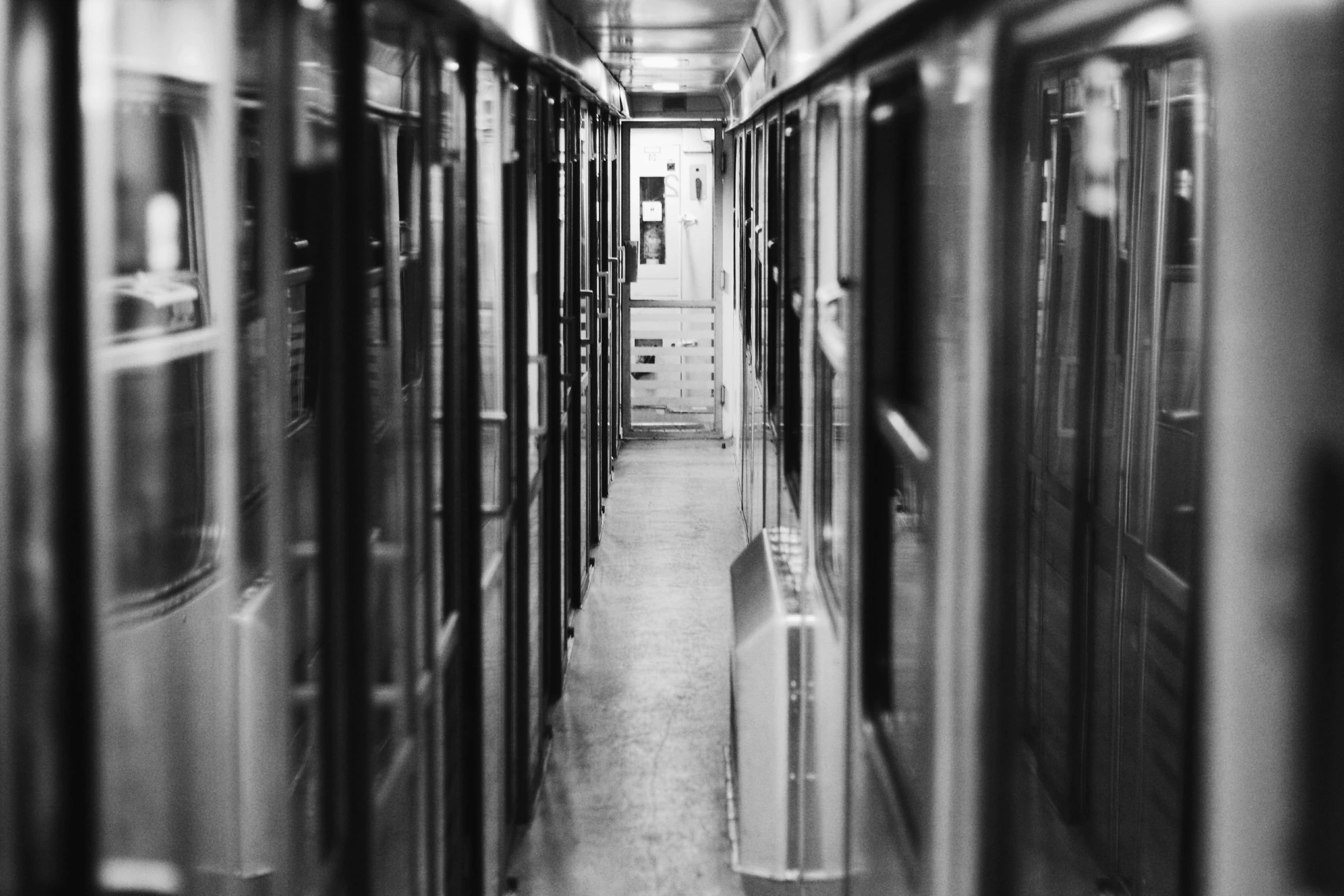 a black and white photo of a subway car, a black and white photo, by Emma Andijewska, rows of doors, servers, taken in the late 2000s, shot on superia 400 filmstock