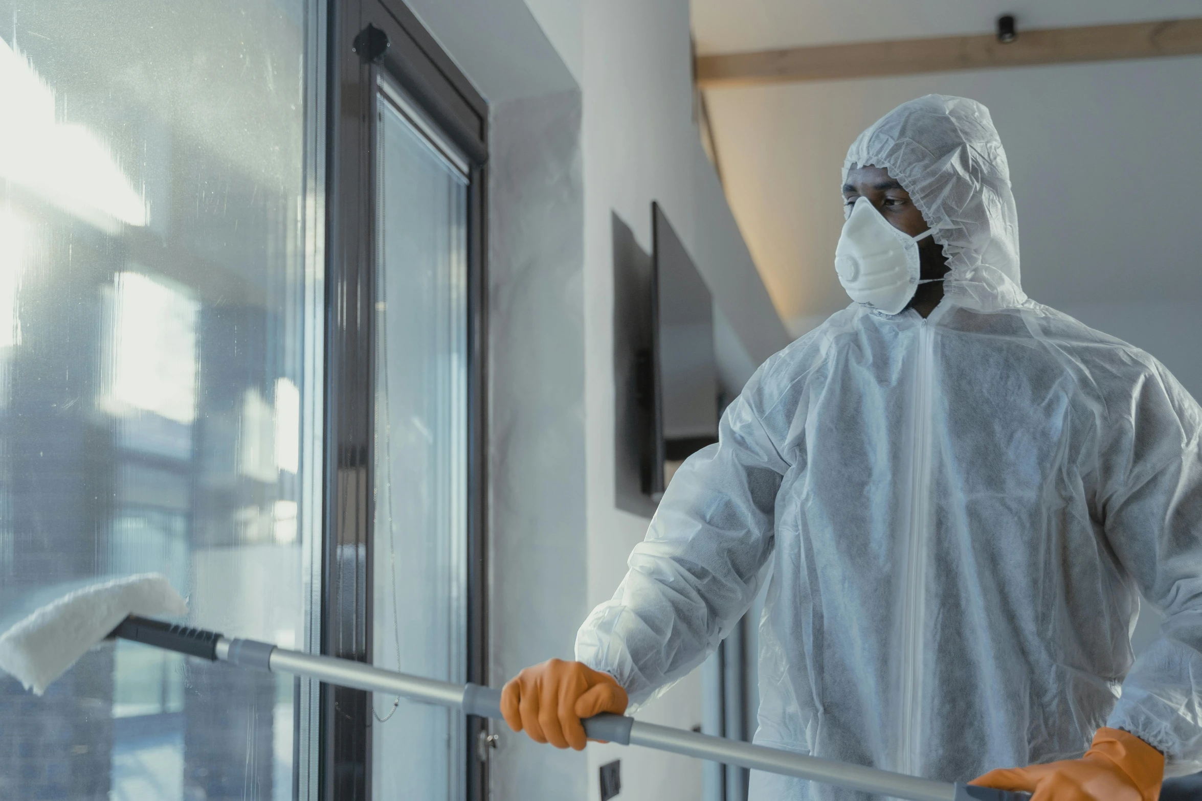 a man in a protective suit standing next to a window, happening, chemrail, holding a thick staff, cinematic, walking down