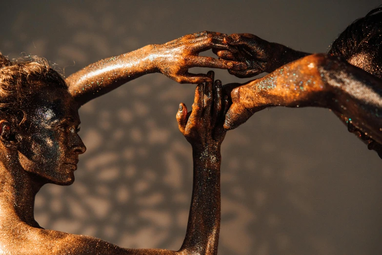 a close up of two hands touching each other, a bronze sculpture, by Eglon van der Neer, pexels contest winner, figurative art, bodypaint, intricate light, chocolate art, intertwined full body view