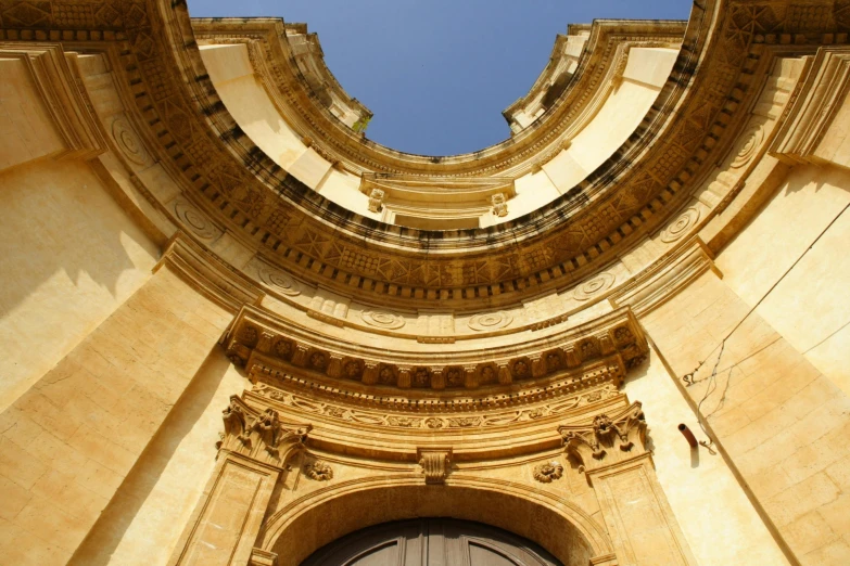 a very tall building with a clock on it's side, inspired by Fede Galizia, baroque, tall arched stone doorways, looking up onto the sky, roman bath, round-cropped