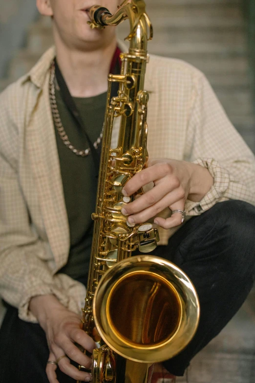 a man that is sitting down with a saxophone, trending on pexels, photorealism, wearing gilded ribes, lachlan bailey, closeup of arms, smooth pale skin