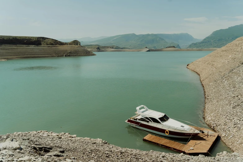 a boat sitting on top of a body of water, by Muggur, can basdogan, water reservoir, 2022 photograph, slide show