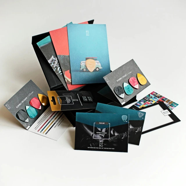 a pile of business cards sitting on top of each other, an album cover, pexels contest winner, black and aqua colors, technicolour 1, inside its box, ball shaped accordion sleeve