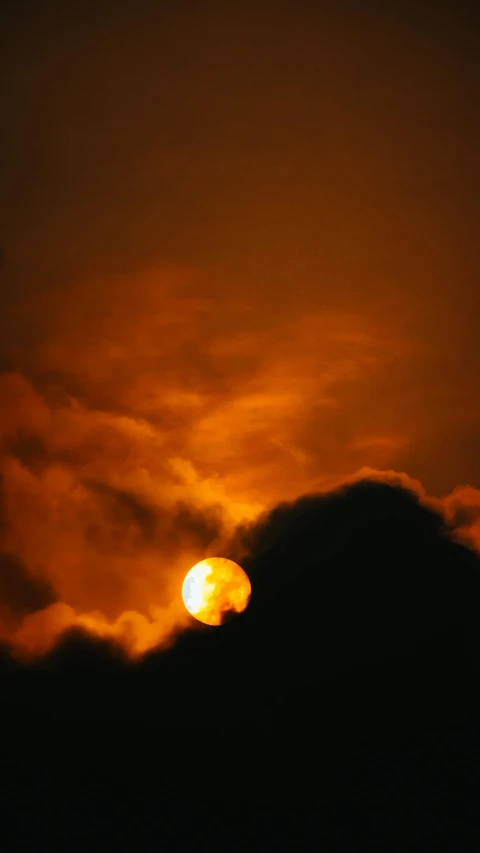 the sun is setting behind the clouds, by Dave Allsop, digital yellow red sun, photographed for reuters, a surreal