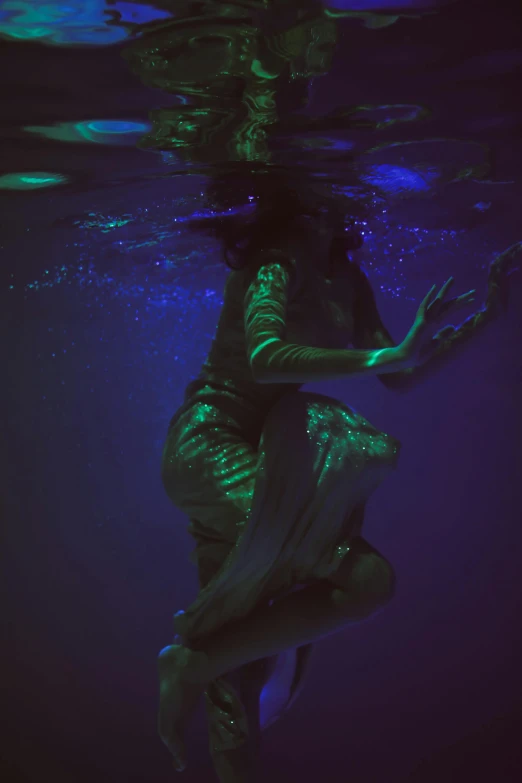 a woman that is standing in the water, an album cover, inspired by Brooke Shaden, unsplash, conceptual art, blue and green light, ultraviolet photography, low iso, at nighttime